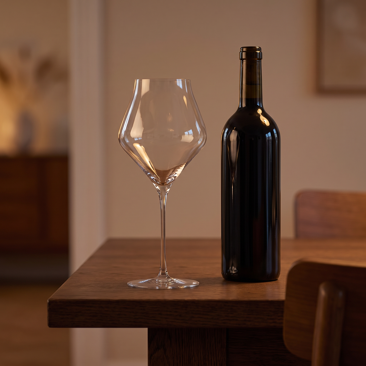 Kristal wijnglas van 760 ml naast wijnfles op eettafel
